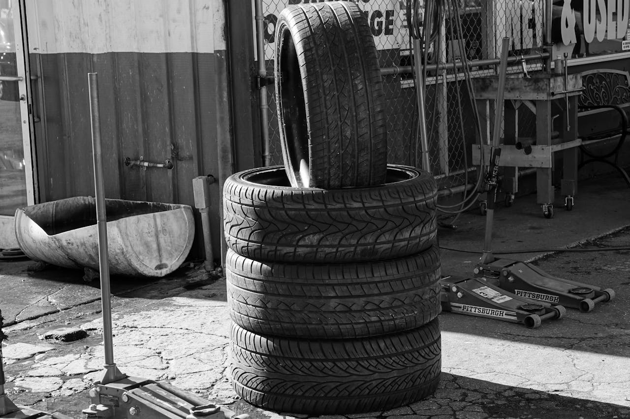 services-03 Black and white photo of stacked tires in a garage environment highlighting industrial themes.